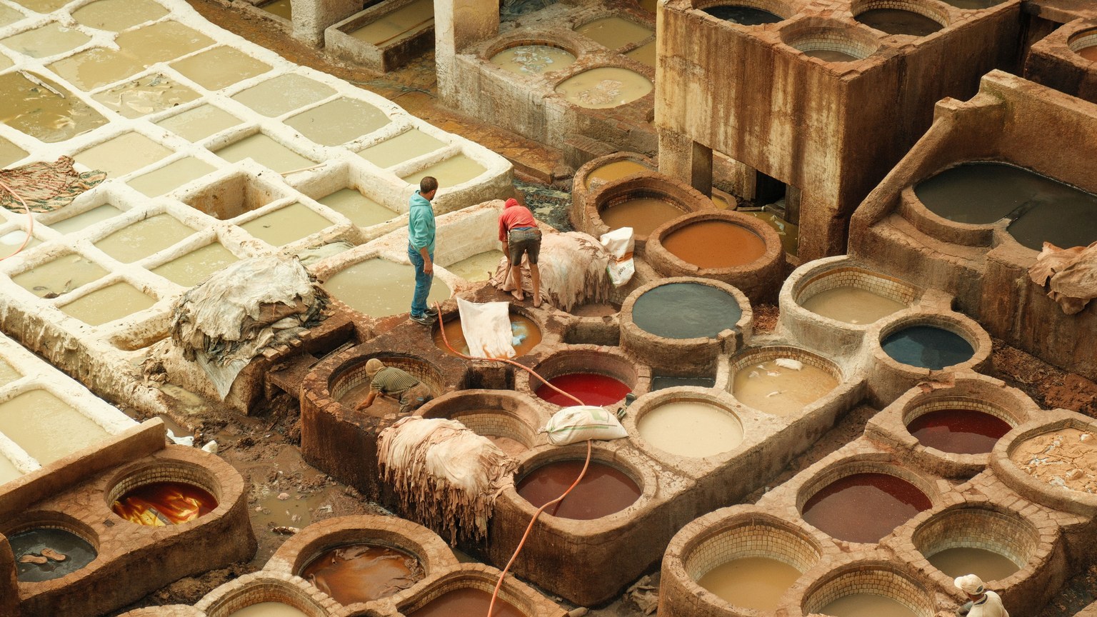 Aerial view of a traditional leather tannery in Fes, Morocco, showcasing colorful dye pits.