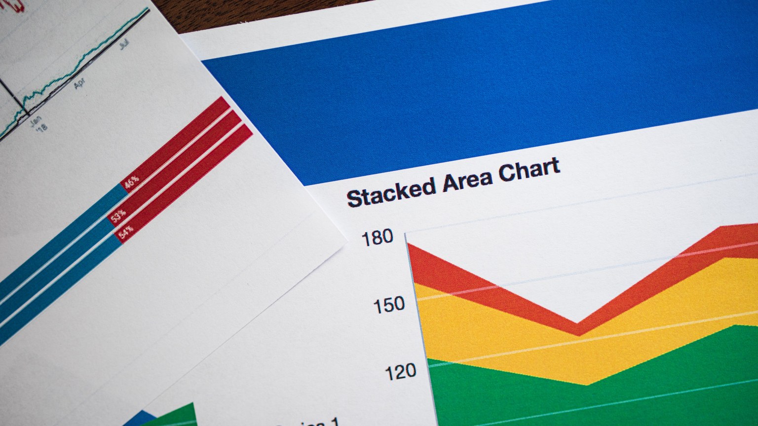 Vivid stacked area chart and graphs on paper, showcasing data analysis.