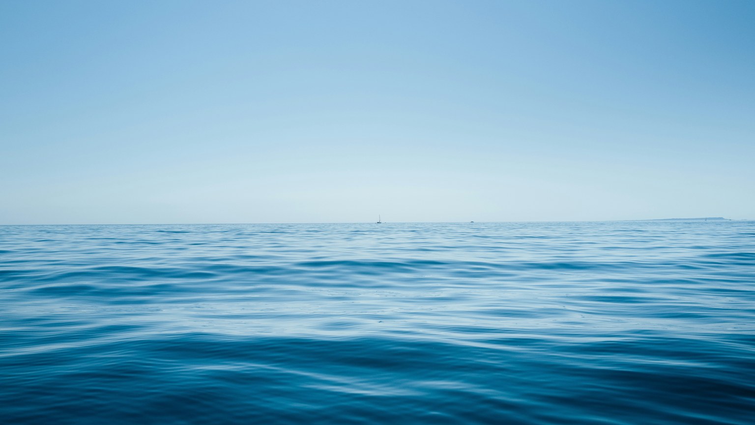 A tranquil view of the endless ocean under a clear blue sky, shot from England's coast.