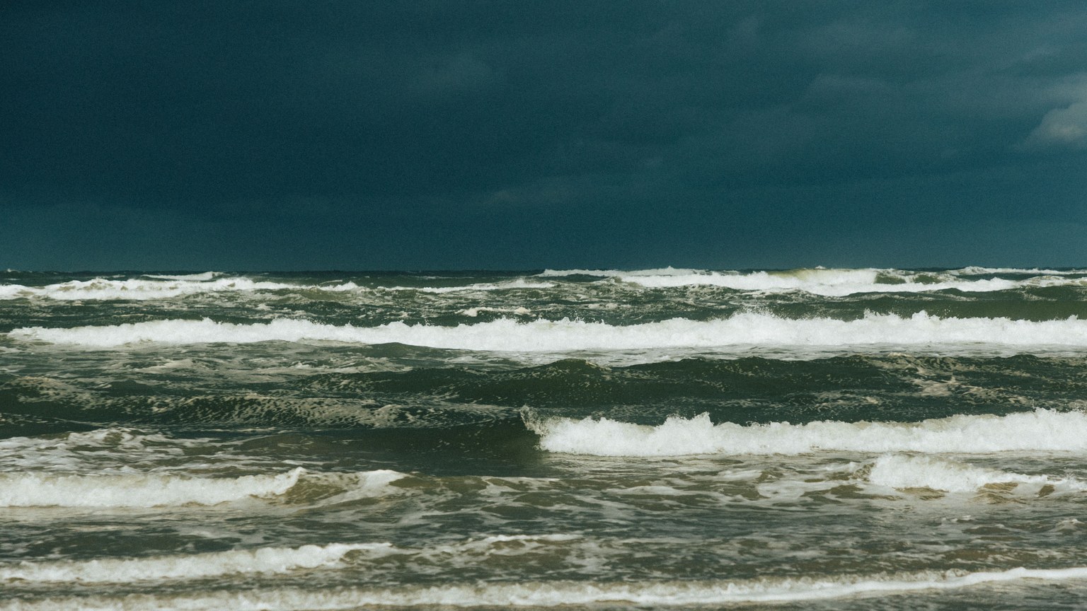 Captivating view of a stormy sea under dark clouds, showcasing powerful ocean waves.
