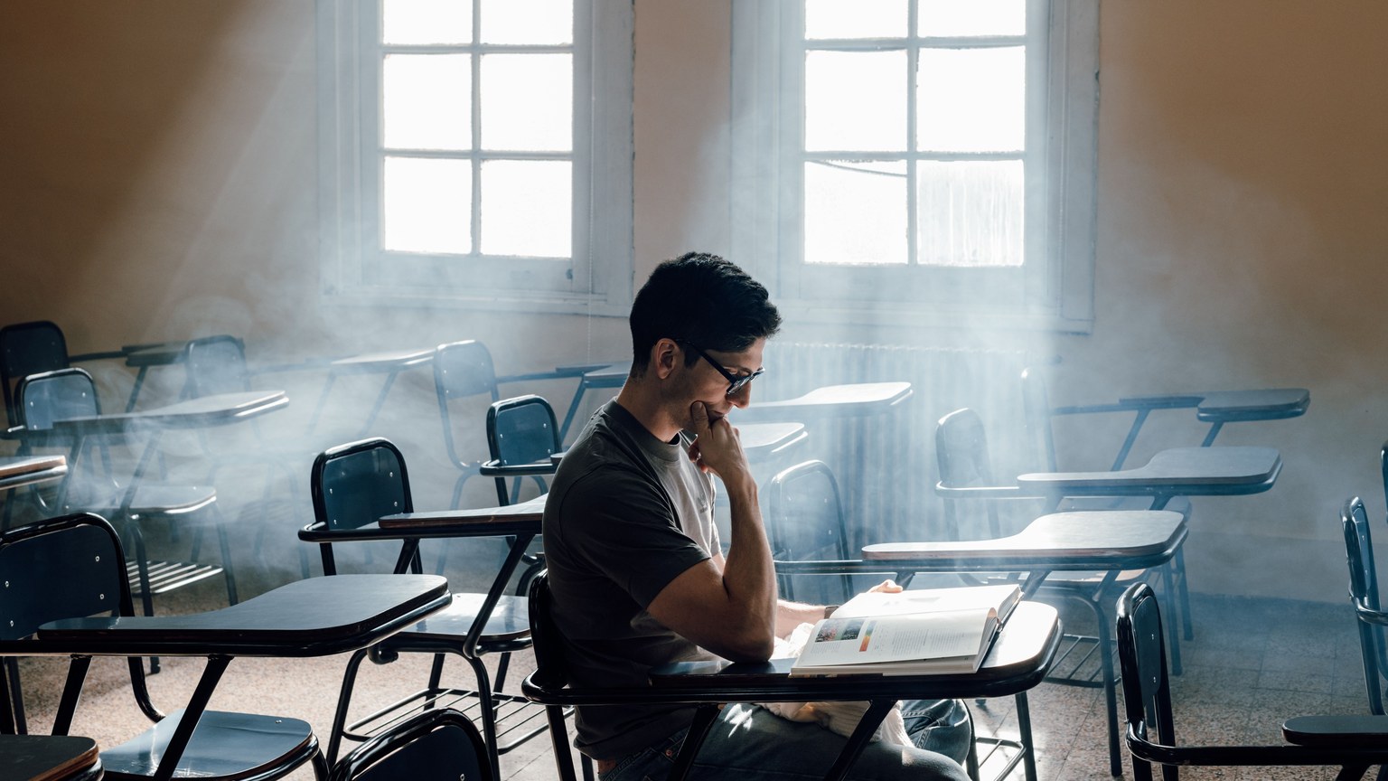 University student studies alone in a sunlit classroom, Buenos Aires, Argentina.