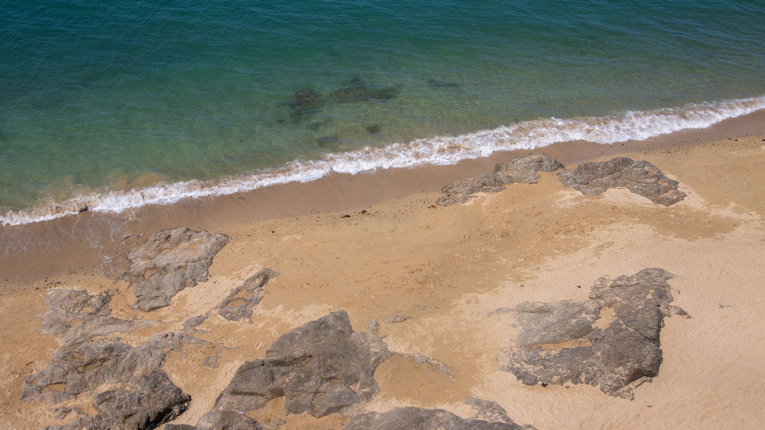 A tranquil sandy beach with rocky formations at Saint-Malo, Brittany, France.