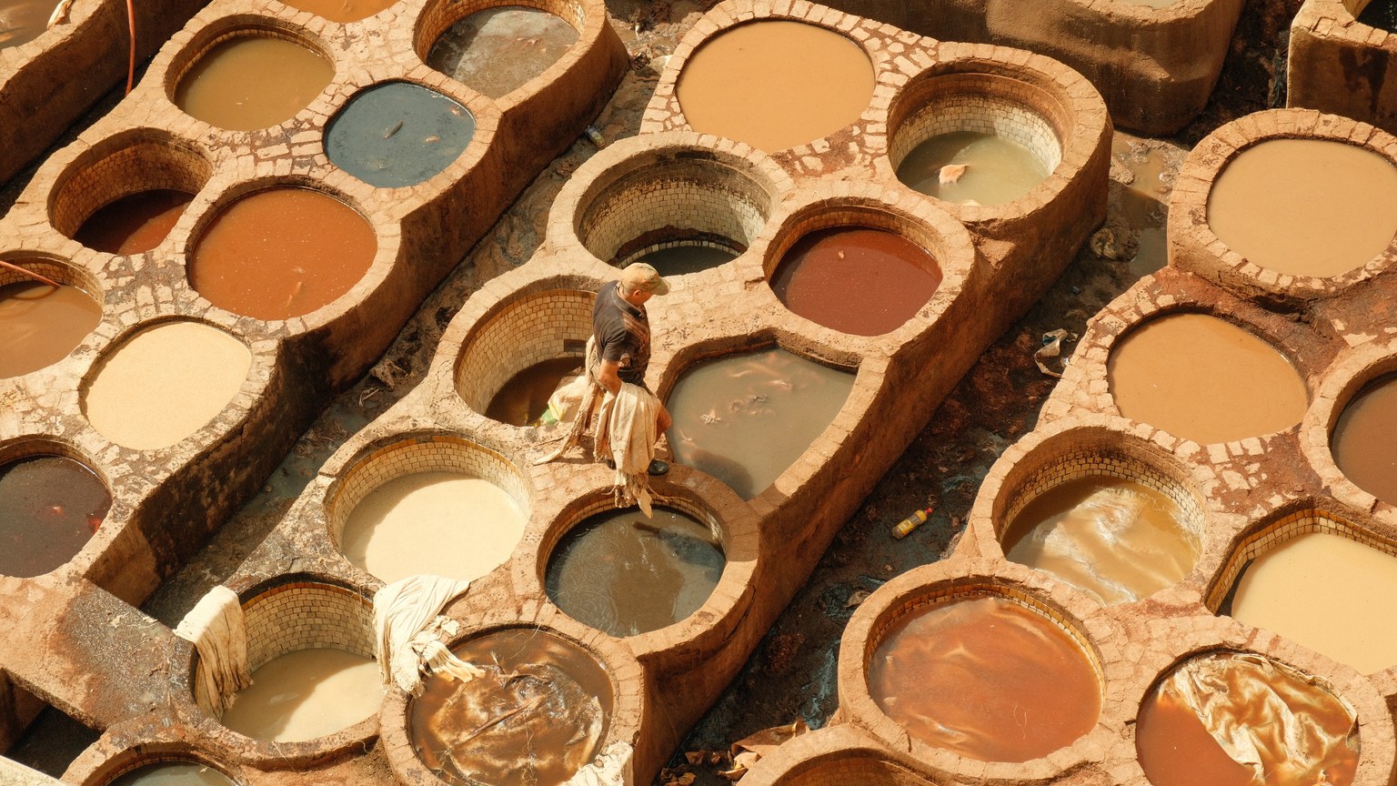 Overhead view of a traditional leather tannery in Fes with various color dye pits.