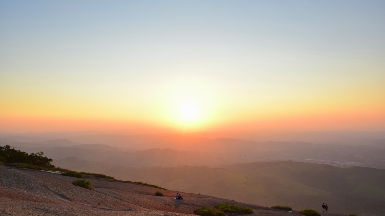 A breathtaking sunrise over a vast mountainous landscape with clear skies.