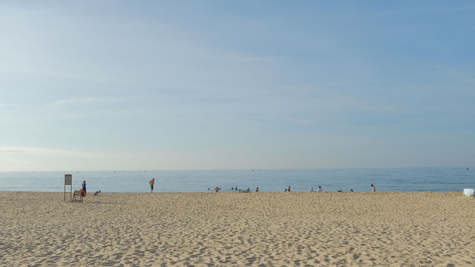 A peaceful beach day in Binh Thuan, Vietnam, with people enjoying the sunny atmosphere and calm sea.