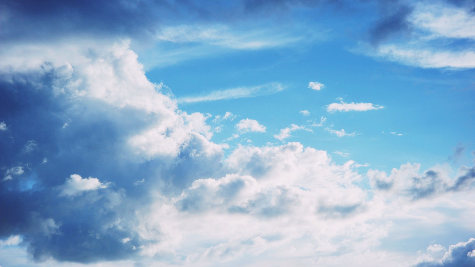 A stunning view of a bright blue sky filled with fluffy clouds, capturing a serene and peaceful atmosphere.