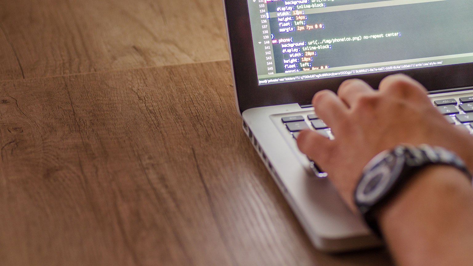 Close-up of a person coding on a laptop, showcasing web development and programming concepts.