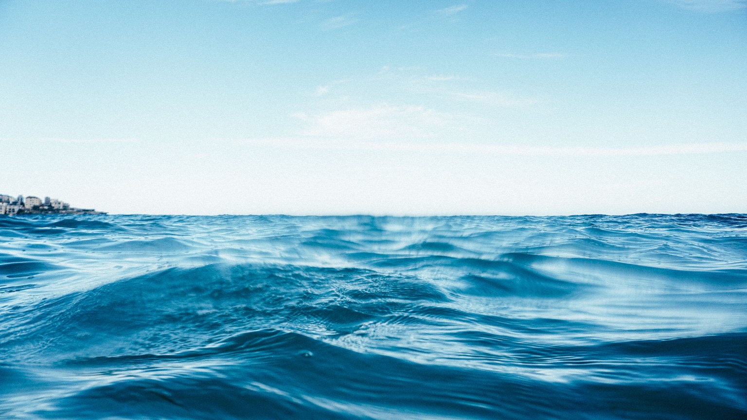 Clear blue water of sea with ripples and wavy surface under bright blue sky