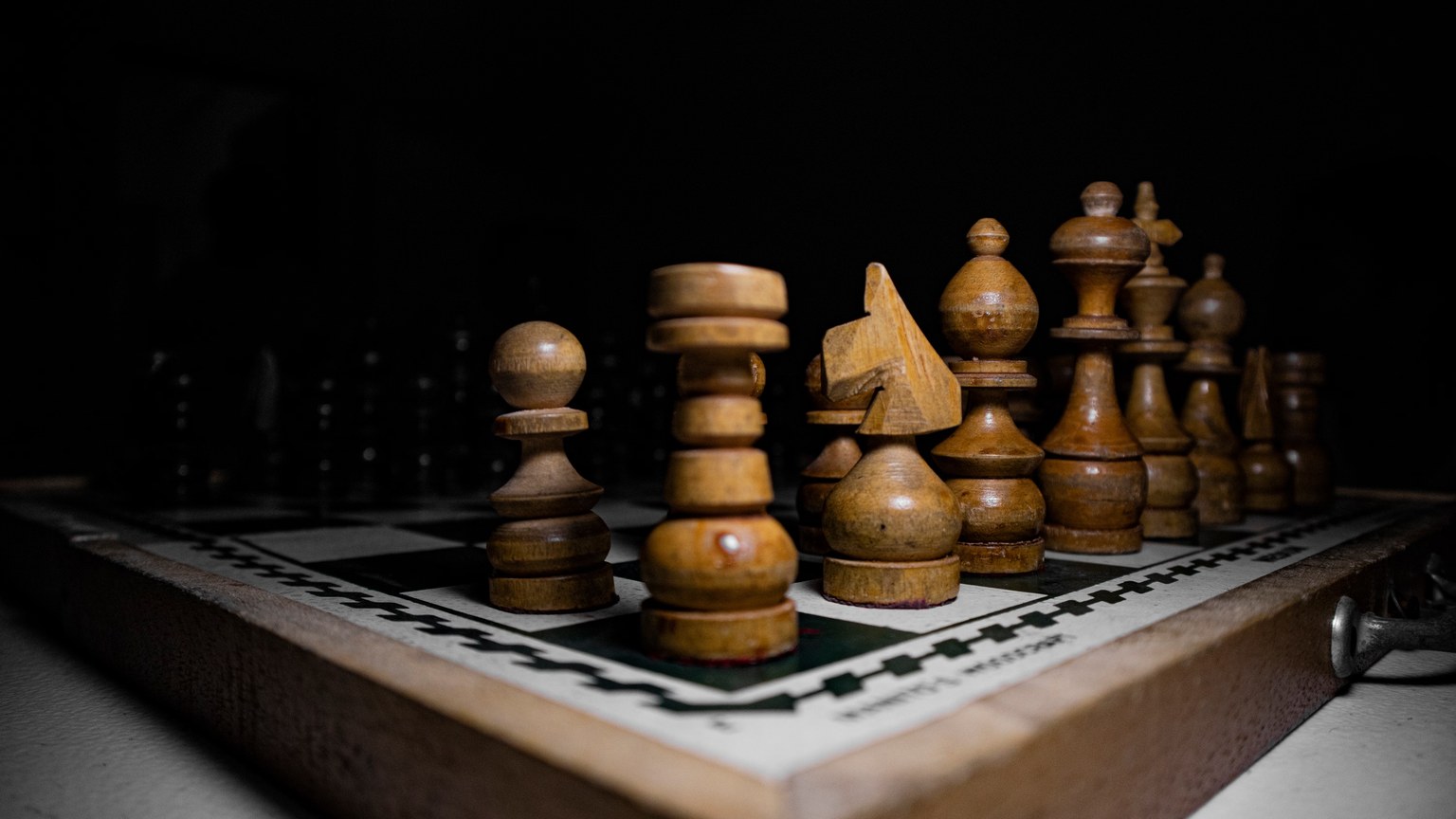 Close-up of wooden chess pieces on a board, emphasizing strategy and tactics.