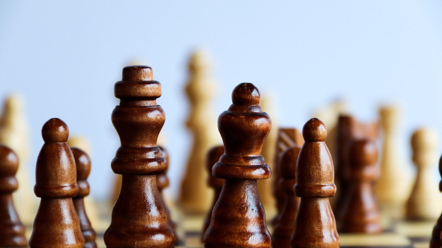 Detailed view of wooden chess pieces on a board, capturing strategy in play.