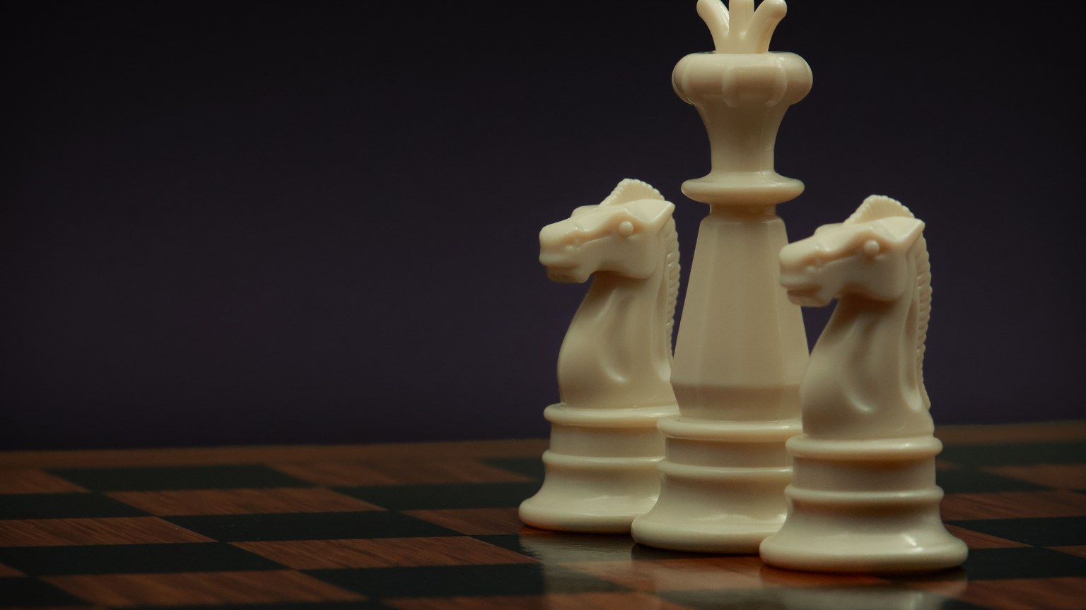 Elegant chess pieces on a board, featuring two knights and a king, symbolizing strategy and planning.
