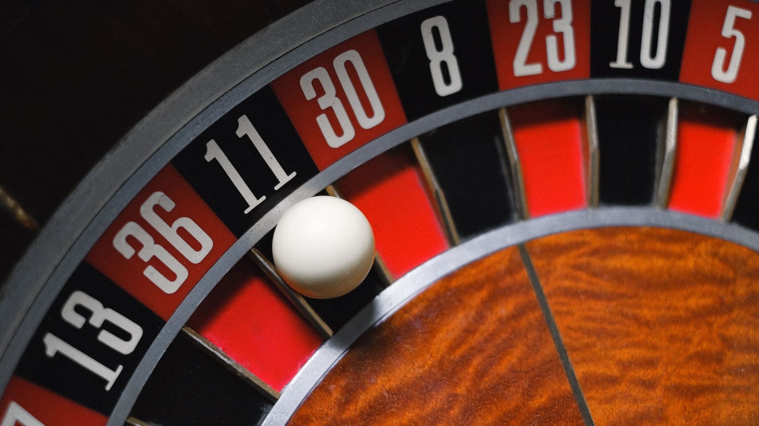 Detailed view of a roulette wheel with a ball, emphasizing the excitement of gambling.