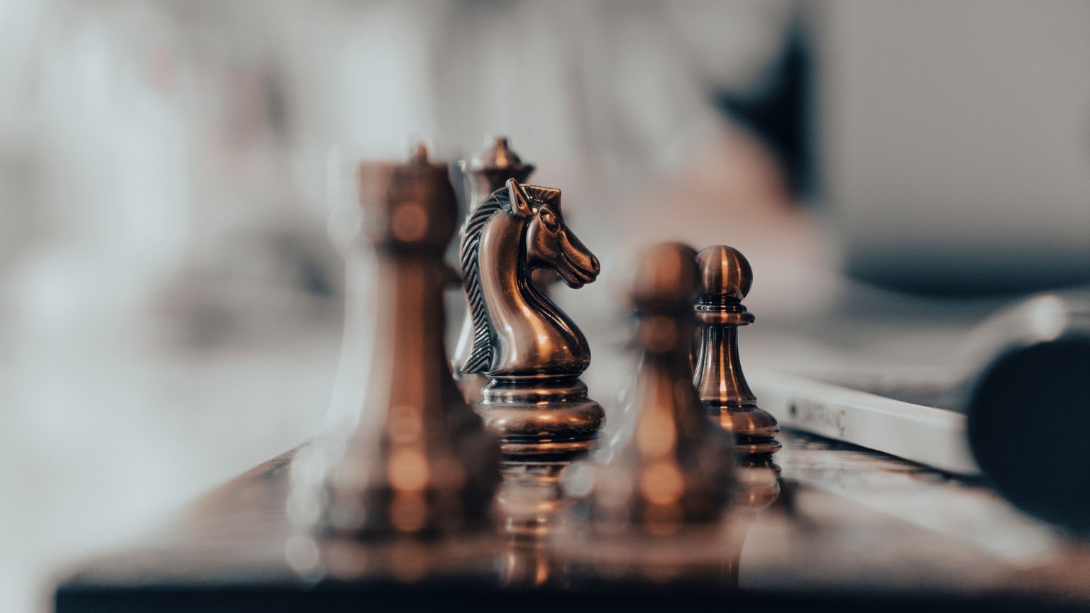 A detailed close-up of chess pieces on a board, highlighting the knight in warm tones.