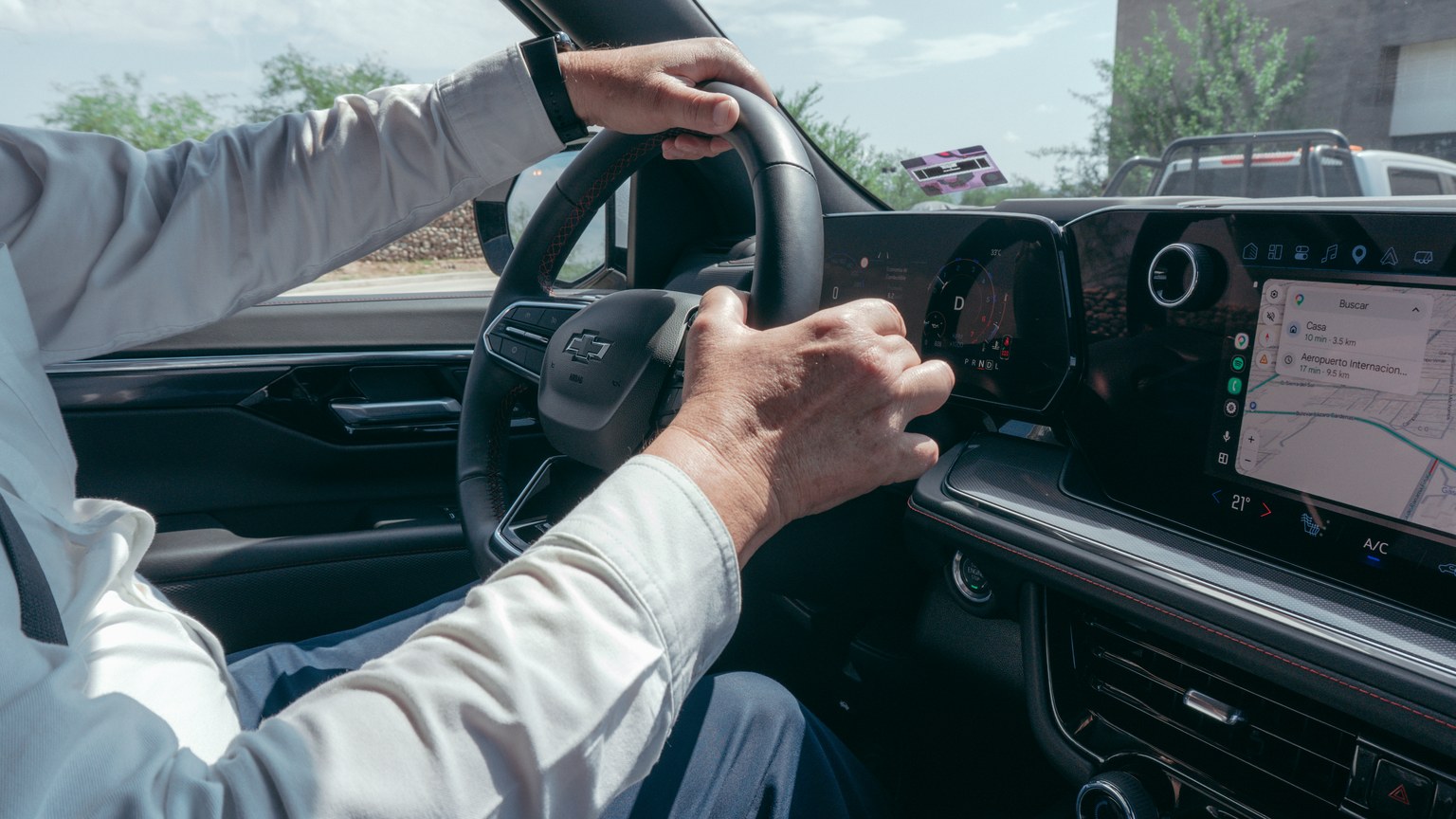 A person driving a modern car while using the built-in GPS navigation system.