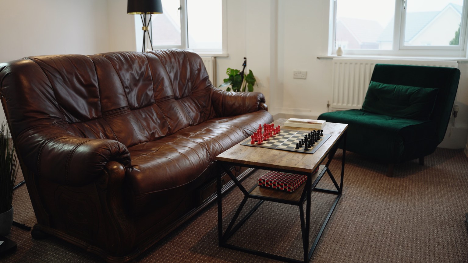 Stylish living room featuring a leather sofa, chess set, and modern decor for a cozy ambiance.