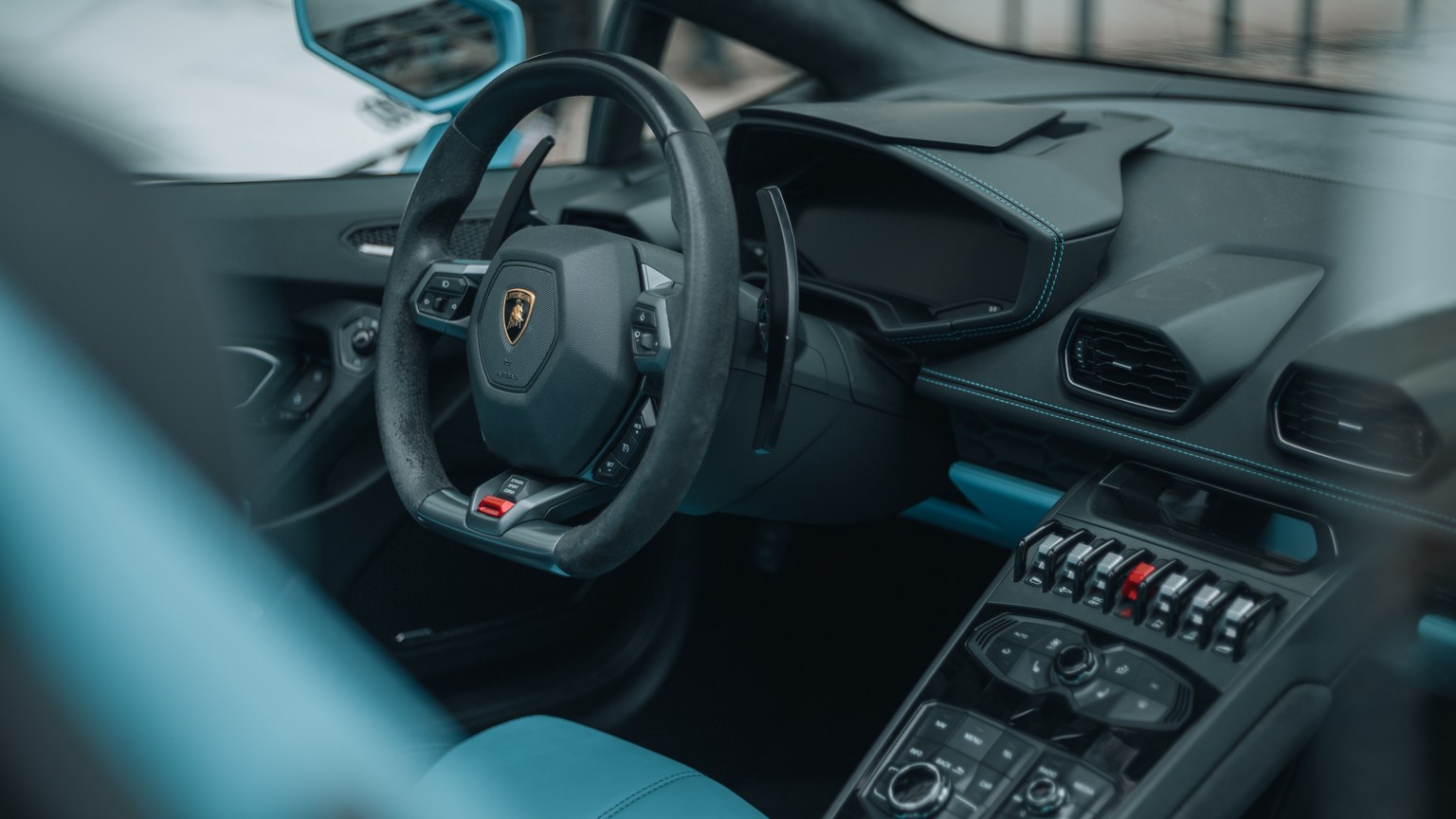 Detailed view of a luxury sports car interior featuring sleek blue accents and modern design elements.