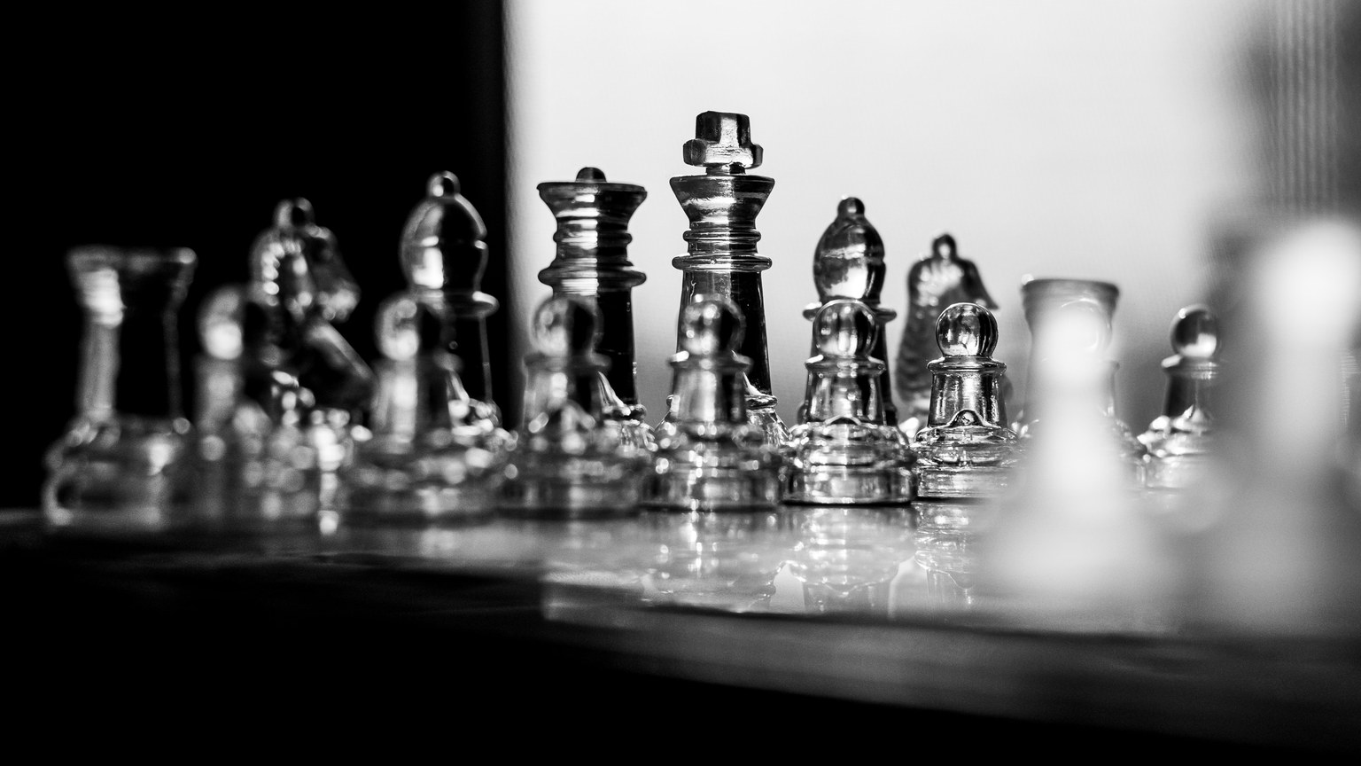 Elegant black and white image of crystal chess pieces arranged on a board, showcasing clarity and sophistication.