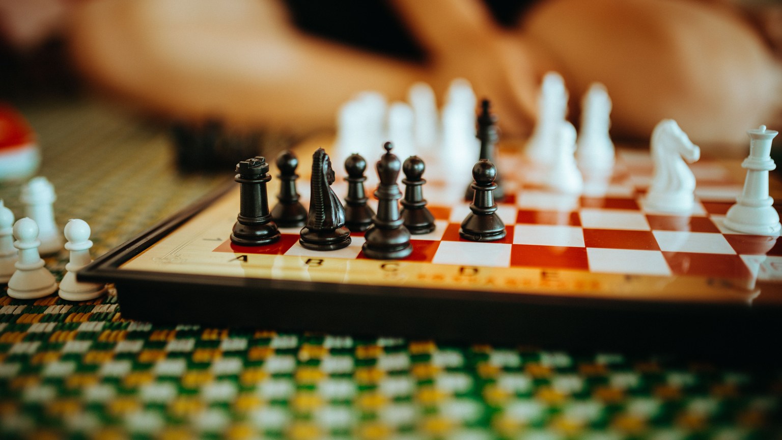 Close-up of a chess board with pieces on a checkered mat, Kon Tum, Vietnam.